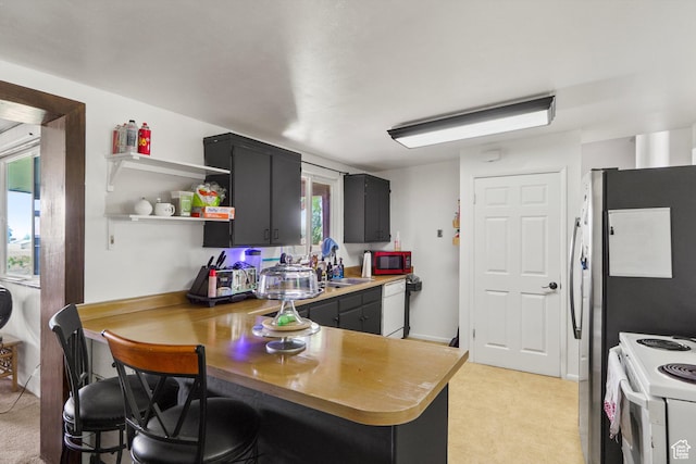 4299 Monroe Blvd, South Ogden, UT 84403 - kitchen featuring white appliances, a peninsula, dark cabinets, light countertops, and open shelves