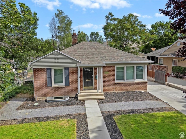 2009 E Hollywood Ave, Salt Lake City, UT 84108 - bungalow-style home featuring brick siding, a shingled roof, and a chimney