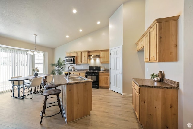 2051 E 1180 S, Spanish Fork, UT 84660 - kitchen with black range with gas stovetop, stainless steel microwave, dark countertops, wall chimney range hood, and high vaulted ceiling