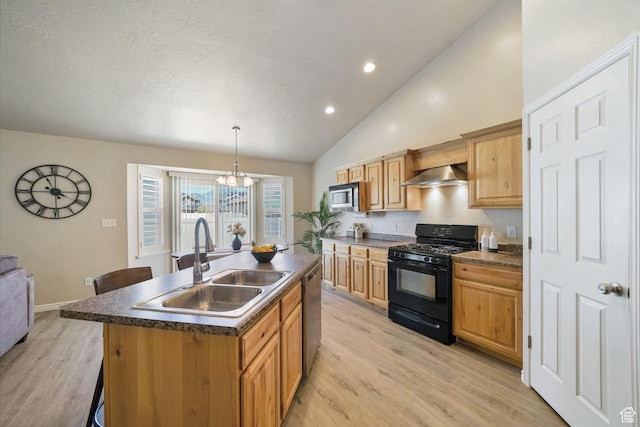 2051 E 1180 S, Spanish Fork, UT 84660 - kitchen with stainless steel appliances, wall chimney exhaust hood, a center island with sink, dark countertops, and light wood-style floors