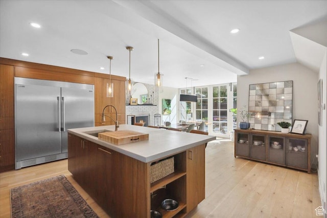2494 E Murray Holladay Rd S, Holladay, UT 84117 - kitchen featuring built in refrigerator, light wood-style flooring, a brick fireplace, modern cabinets, and recessed lighting