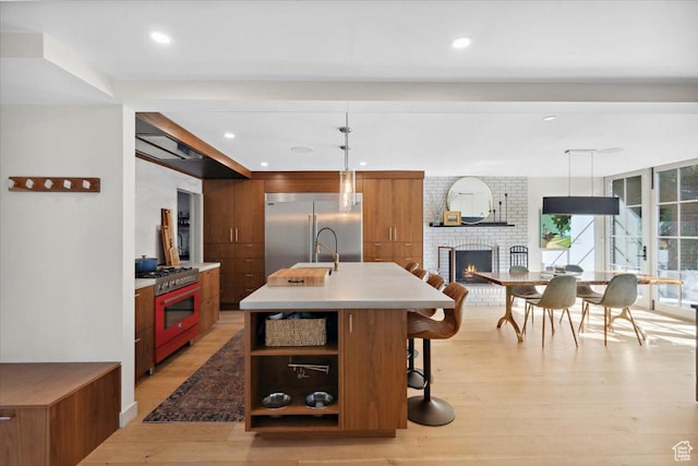 2494 E Murray Holladay Rd S, Holladay, UT 84117 - kitchen featuring high end appliances, brown cabinetry, modern cabinets, light wood finished floors, and recessed lighting