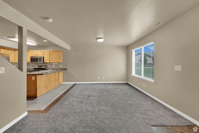 419 E 475 N, Ogden, UT 84404 - kitchen with light brown cabinetry, carpet flooring, stainless steel appliances, a peninsula, and open floor plan