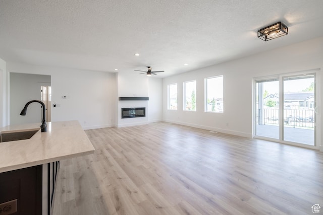 335 E Ventura Blvd, Stansbury Park, UT 84074 - unfurnished living room featuring healthy amount of natural light, recessed lighting, a textured ceiling, light wood-style flooring, and ceiling fan