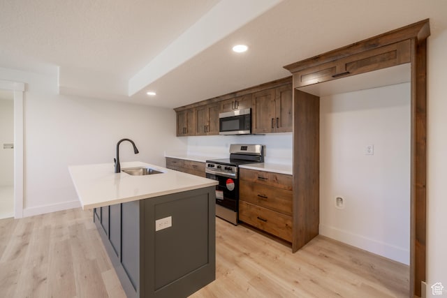 335 E Ventura Blvd, Stansbury Park, UT 84074 - kitchen with appliances with stainless steel finishes, an island with sink, light wood-style floors, recessed lighting, and light countertops