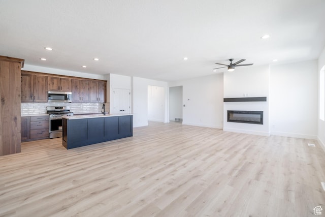 335 E Ventura Blvd, Stansbury Park, UT 84074 - kitchen with appliances with stainless steel finishes, ceiling fan, recessed lighting, tasteful backsplash, and an island with sink