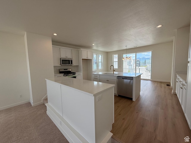 6927 W S Jordan Pkwy, South Jordan, UT 84009 - kitchen featuring stainless steel appliances, a center island with sink, recessed lighting, light countertops, and white cabinets