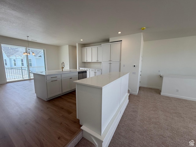 6927 W S Jordan Pkwy, South Jordan, UT 84009 - kitchen with a center island with sink, a chandelier, stainless steel dishwasher, white cabinetry, and light countertops