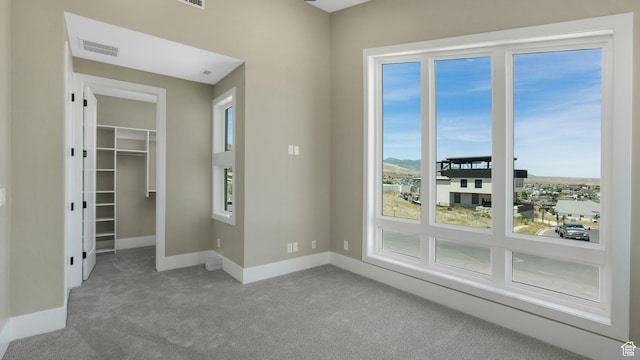 7233 W Summit Top Ln, Herriman, UT 84096 - unfurnished bedroom featuring carpet flooring, multiple windows, a walk in closet, and a closet