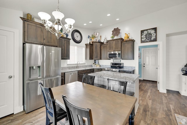 369 E Shelley Ln, Grantsville, UT 84029 - kitchen featuring appliances with stainless steel finishes, a chandelier, dark brown cabinets, wood finished floors, and recessed lighting