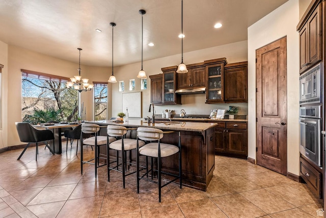 4962 W Boulder Vw, Hurricane, UT 84737 - kitchen with appliances with stainless steel finishes, under cabinet range hood, a kitchen breakfast bar, a kitchen island with sink, and a chandelier