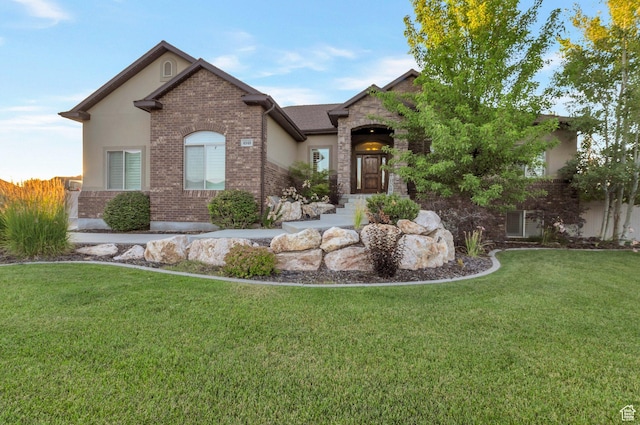4948 W 4025 S, West Haven, UT 84401 - view of front of house featuring a front yard, stucco siding, and brick siding
