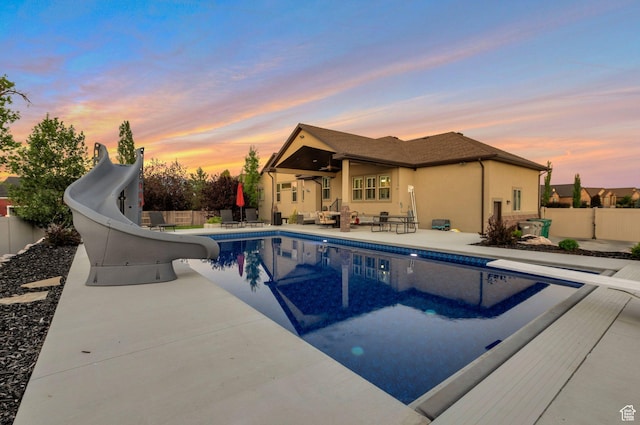4948 W 4025 S, West Haven, UT 84401 - pool at dusk with a water slide, a patio, and a diving board