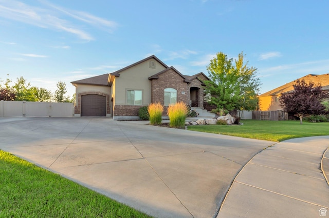 4948 W 4025 S, West Haven, UT 84401 - view of front facade featuring driveway, an attached garage, stucco siding, a gate, and brick siding