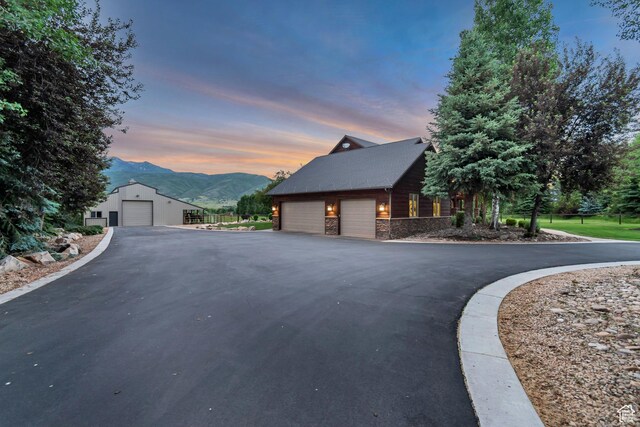 2984 Winterton Rd, Charleston, UT 84032 - view of home's exterior with a mountain view, stone siding, a garage, and an outbuilding