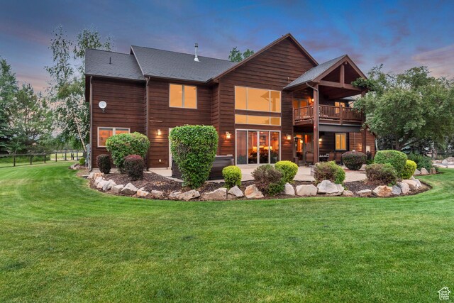 2984 Winterton Rd, Charleston, UT 84032 - back of property at dusk featuring a patio area, a lawn, a shingled roof, and a balcony