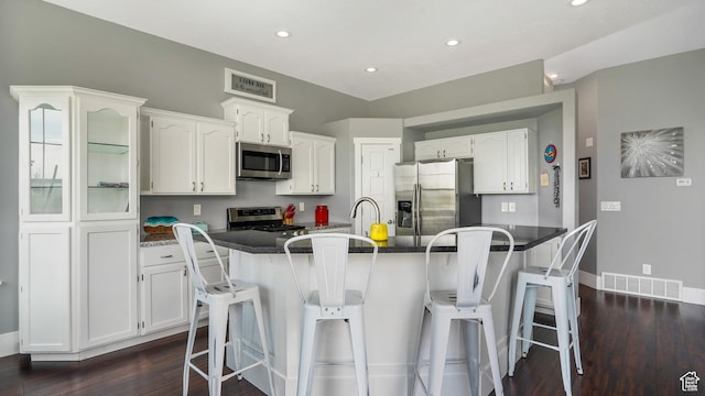 721 W Glovers Ln, Farmington, UT 84025 - kitchen with stainless steel appliances, white cabinets, recessed lighting, a kitchen bar, and dark wood finished floors