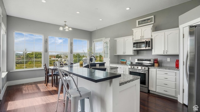 721 W Glovers Ln, Farmington, UT 84025 - kitchen featuring stainless steel appliances, recessed lighting, white cabinetry, a breakfast bar, and a chandelier