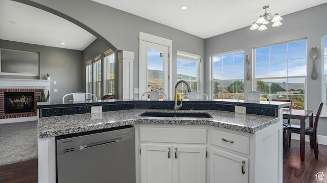 721 W Glovers Ln, Farmington, UT 84025 - kitchen featuring dishwasher, arched walkways, dark wood-type flooring, a brick fireplace, and white cabinets