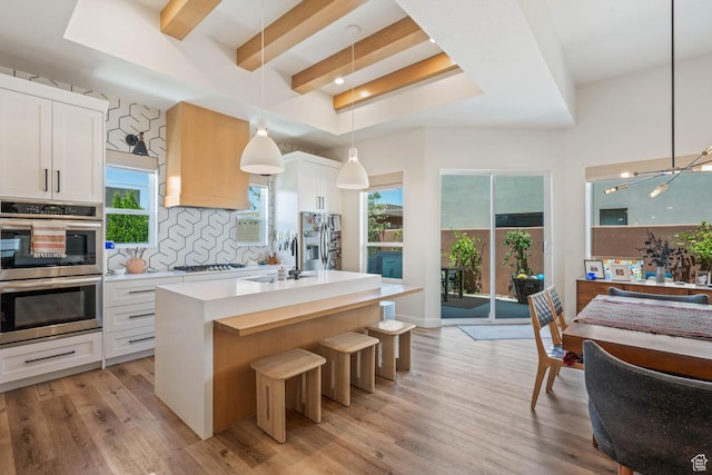 3214 S Red Sands Way, Hurricane, UT 84737 - kitchen with appliances with stainless steel finishes, decorative backsplash, a center island with sink, light countertops, and pendant lighting