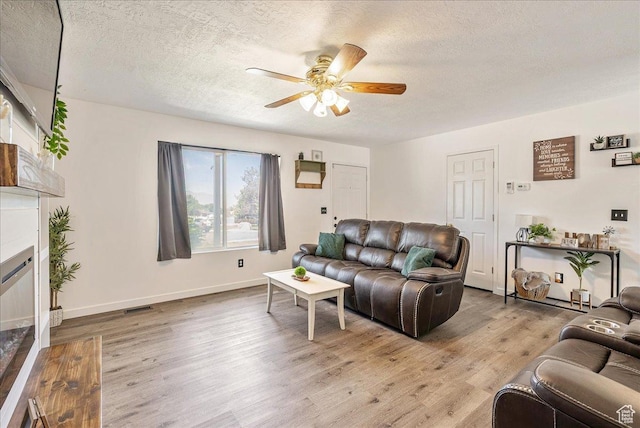 655 S 100 W, Santaquin, UT 84655 - living area with a ceiling fan, a textured ceiling, light wood-type flooring, and a glass covered fireplace