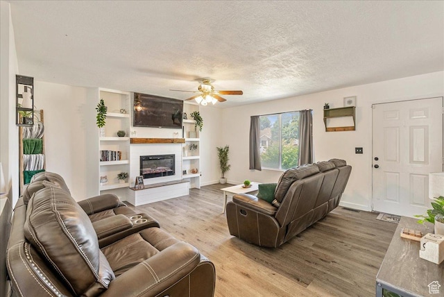 655 S 100 W, Santaquin, UT 84655 - living room with a ceiling fan, light wood-type flooring, a textured ceiling, and a glass covered fireplace