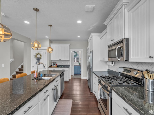 4966 W Willamette Way S, South Jordan, UT 84095 - kitchen featuring appliances with stainless steel finishes, white cabinetry, dark wood finished floors, backsplash, and recessed lighting