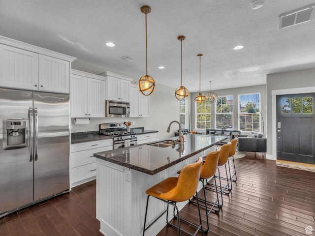 4966 W Willamette Way S, South Jordan, UT 84095 - kitchen featuring appliances with stainless steel finishes, dark wood-style flooring, a textured ceiling, white cabinets, and recessed lighting
