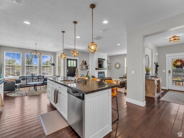 4966 W Willamette Way S, South Jordan, UT 84095 - kitchen featuring stainless steel dishwasher, dark wood-style flooring, open floor plan, white cabinetry, and a kitchen breakfast bar