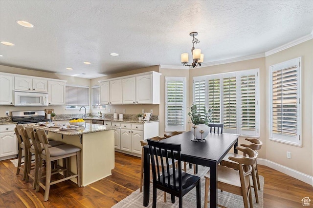 677 E 2900 N, North Ogden, UT 84414 - kitchen with white microwave, gas range, white cabinets, a textured ceiling, and a chandelier