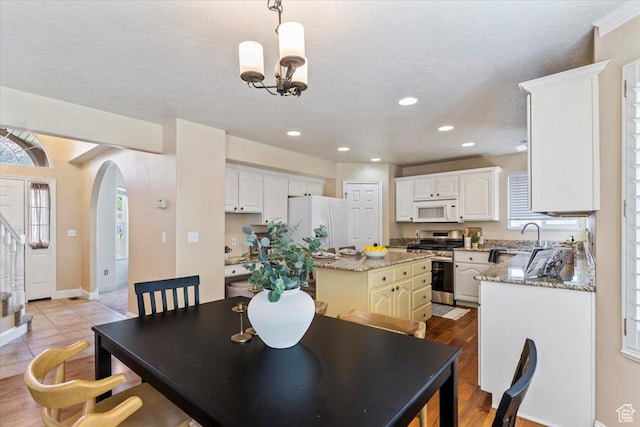 677 E 2900 N, North Ogden, UT 84414 - dining room with a chandelier, arched walkways, recessed lighting, and stairs