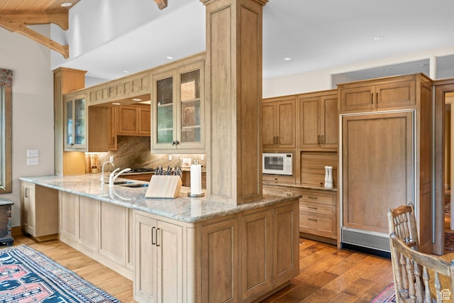 6033 S 2300 E, Holladay, UT 84121 - kitchen with light wood-style flooring, white microwave, backsplash, a peninsula, and light stone countertops