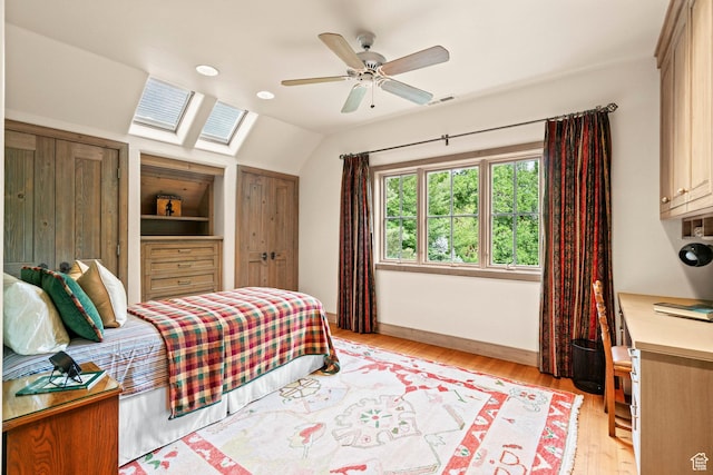 6033 S 2300 E, Holladay, UT 84121 - bedroom with a skylight, vaulted ceiling, light wood-style floors, two closets, and ceiling fan