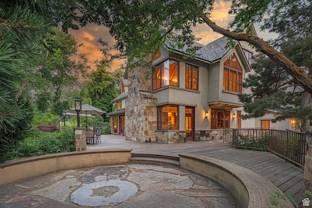 6033 S 2300 E, Holladay, UT 84121 - rear view of house with stone siding, stucco siding, a deck, and outdoor dining area