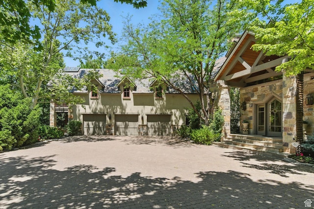6033 S 2300 E, Holladay, UT 84121 - exterior space with asphalt driveway, stone siding, stucco siding, and a garage