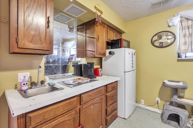 1162 N Newport Ln E, Kaysville, UT 84037 - kitchen with freestanding refrigerator, black microwave, brown cabinets, light countertops, and light colored carpet