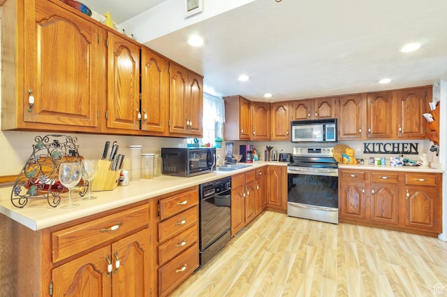 1162 N Newport Ln E, Kaysville, UT 84037 - kitchen featuring black appliances, brown cabinetry, light wood-style floors, light countertops, and recessed lighting