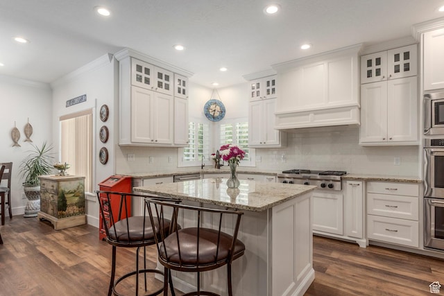 9532 S Willow Trail Way S, Jordan, UT 84095 - kitchen featuring appliances with stainless steel finishes, white cabinetry, dark wood-style flooring, a kitchen bar, and crown molding