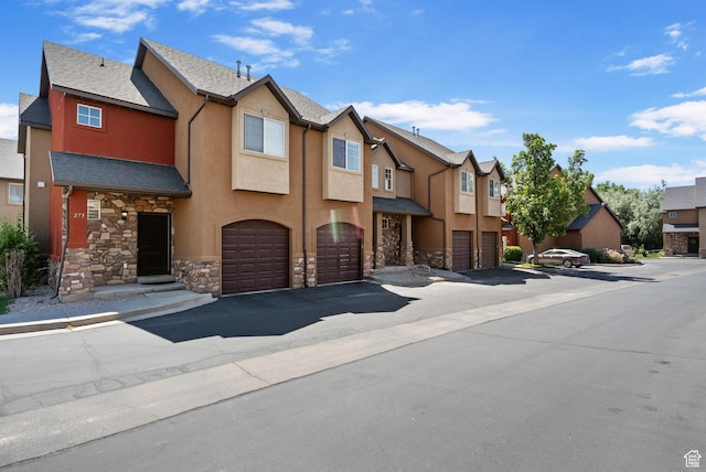 283 S 840 W, Pleasant Grove, UT 84062 - view of property featuring stone siding, a residential view, a garage, stucco siding, and driveway