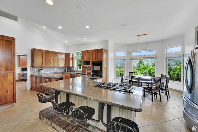 3990 Summer Ridge Rd, Morgan, UT 84050 - kitchen with stainless steel appliances, recessed lighting, brown cabinets, a kitchen bar, and light tile patterned floors