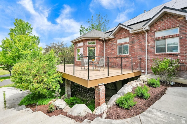 3990 Summer Ridge Rd, Morgan, UT 84050 - view of side of property featuring brick siding, a deck, roof mounted solar panels, and outdoor dining space