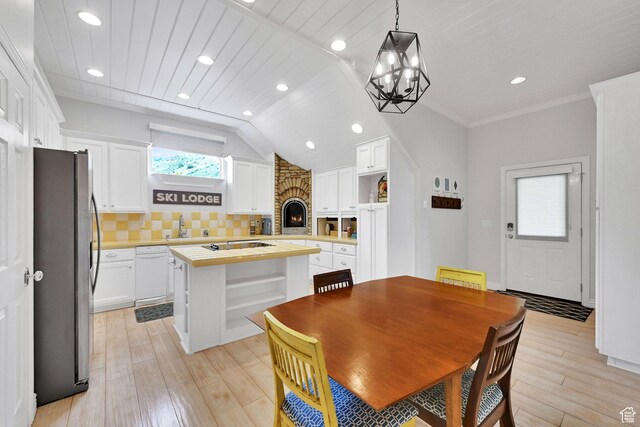 3990 Summer Ridge Rd, Morgan, UT 84050 - dining room featuring light wood-style flooring, a fireplace, a chandelier, recessed lighting, and vaulted ceiling