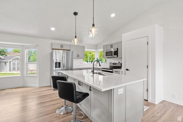 13082 S 2770th Cir W, Riverton, UT 84065 - kitchen featuring stainless steel appliances, gray cabinets, light countertops, a kitchen breakfast bar, and lofted ceiling