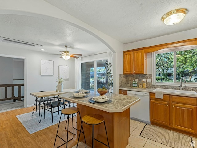 1411 E 1220 N, Logan, UT 84341 - kitchen featuring dishwasher, a textured ceiling, light countertops, decorative backsplash, and a center island