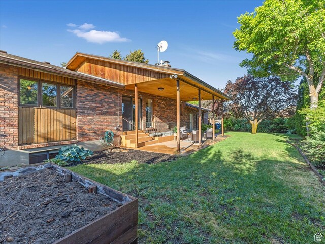 1411 E 1220 N, Logan, UT 84341 - rear view of property featuring a patio, a yard, and brick siding