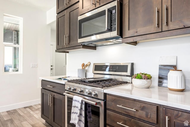 3249 Quarry Springs Dr, Park City, UT 84098 - kitchen with appliances with stainless steel finishes, dark brown cabinets, light wood-type flooring, and light stone counters