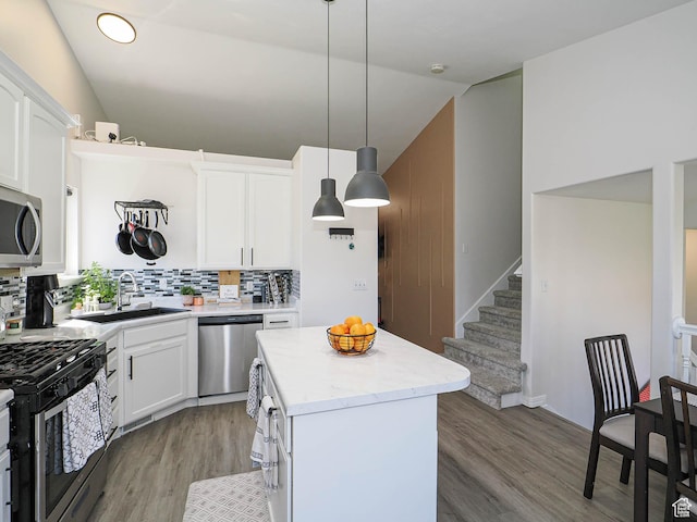 4242 W 11430 S, South Jordan, UT 84009 - kitchen with appliances with stainless steel finishes, vaulted ceiling, light wood-style flooring, backsplash, and a center island