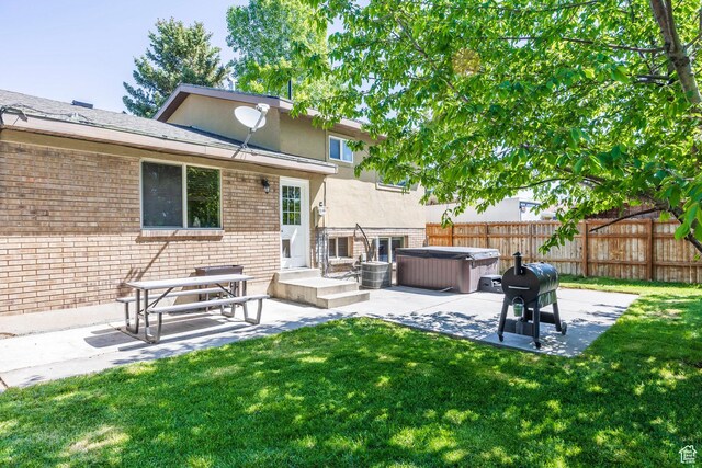 2039 W Camelot S, West Jordan, UT 84084 - rear view of property with a hot tub, a patio, brick siding, and stucco siding