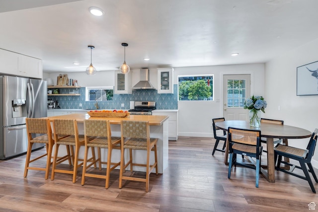 2040 N Oakcrest Ter, Provo, UT 84604 - kitchen featuring stainless steel appliances, wall chimney exhaust hood, backsplash, white cabinetry, and a center island
