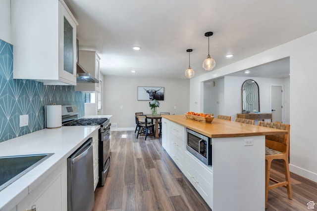 2040 N Oakcrest Ter, Provo, UT 84604 - kitchen with appliances with stainless steel finishes, extractor fan, white cabinets, a kitchen breakfast bar, and dark wood-style flooring